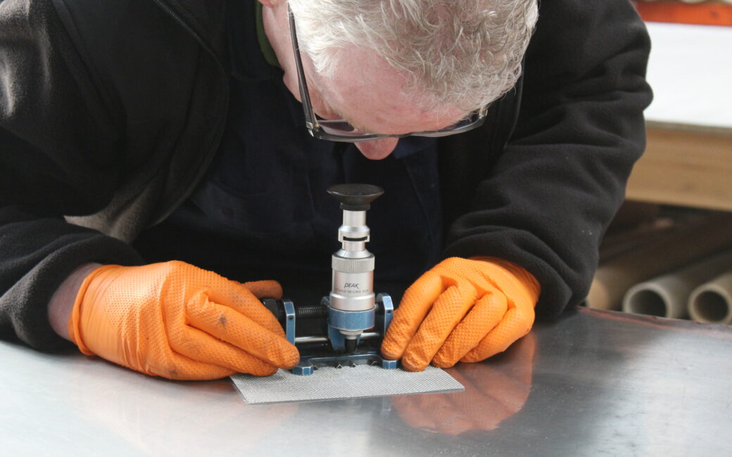A wire mesh expert inspecting fine wire mesh